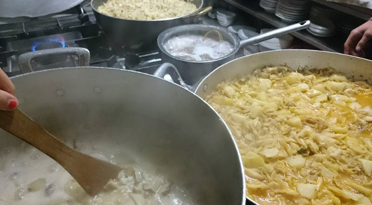Kitchen scene: cooking traditional Bergamo dishes in large pots
