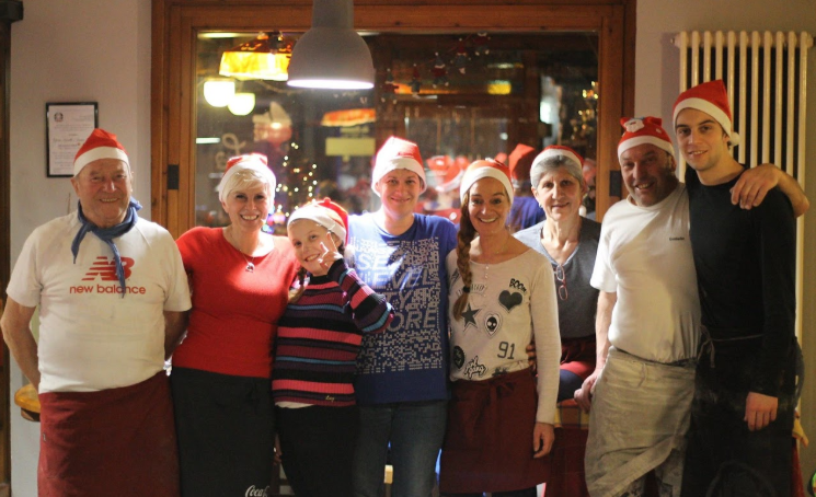 Foto di gruppo della famiglia e dello staff con cappellini natalizi